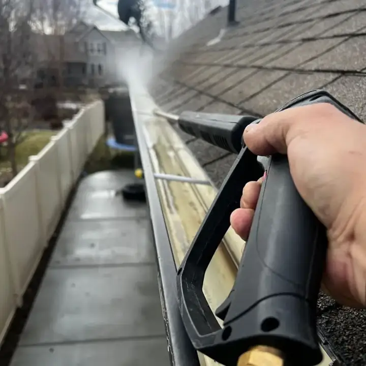 Pressure washing a residential gutter (stock photo)